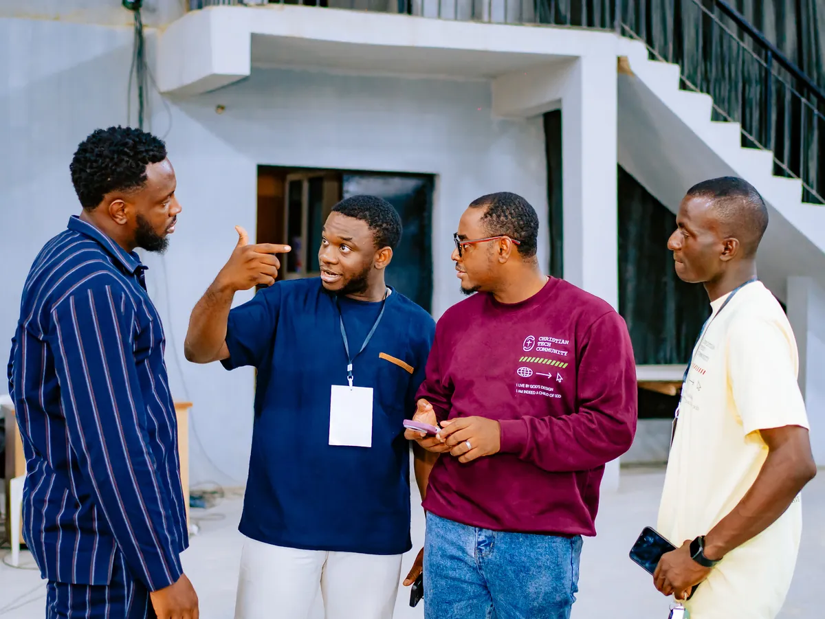 Four men in conversation at CTC 2.0, one pointing as he makes a point and the others laughing.